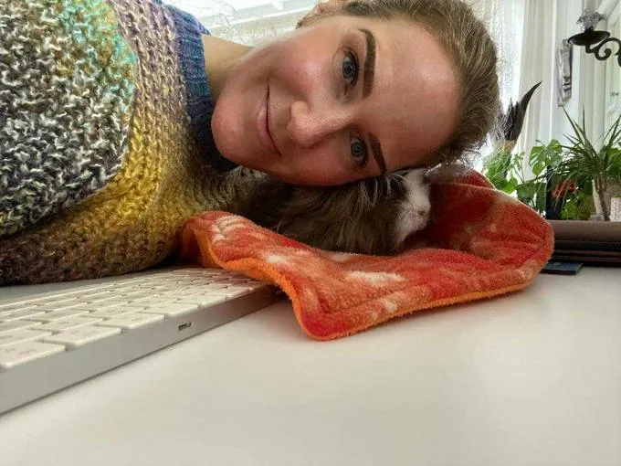 Marianne werkt thuis met haar cavia naast haar